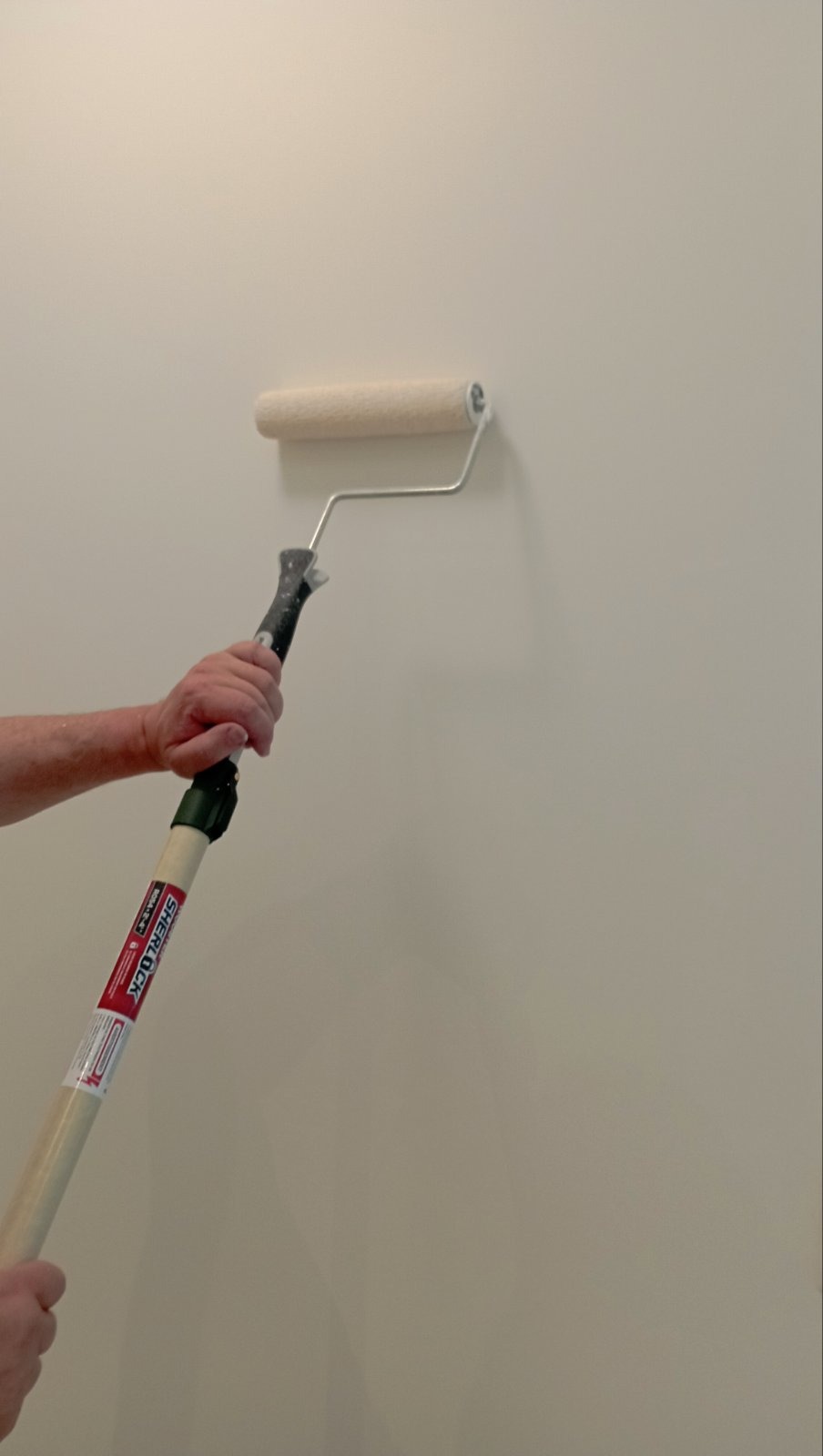 Painter rolling fresh paint onto a wall